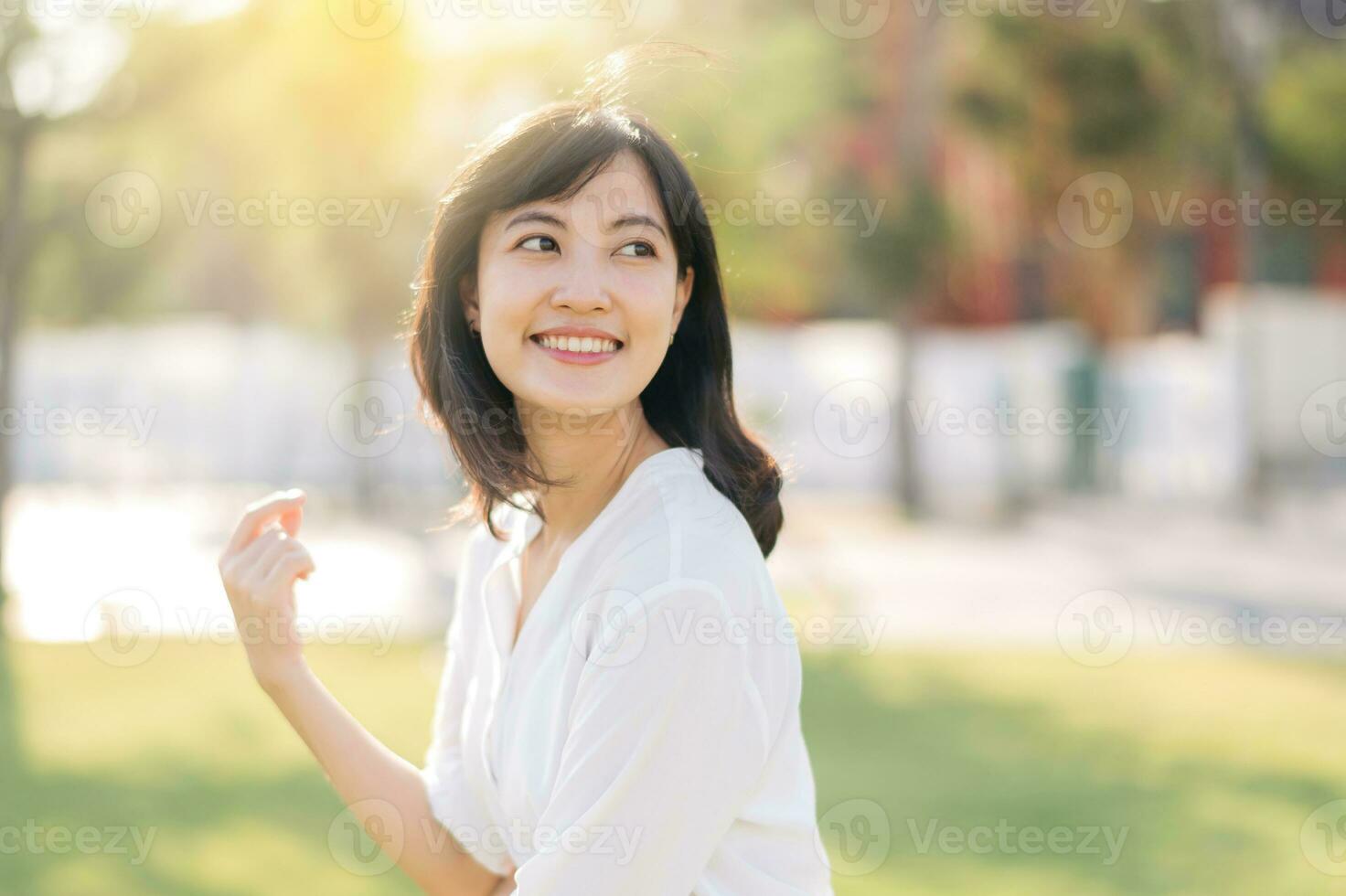 retrato jovem lindo ásia mulher com feliz sorrir por aí ao ar livre parque dentro ensolarado verão dia foto