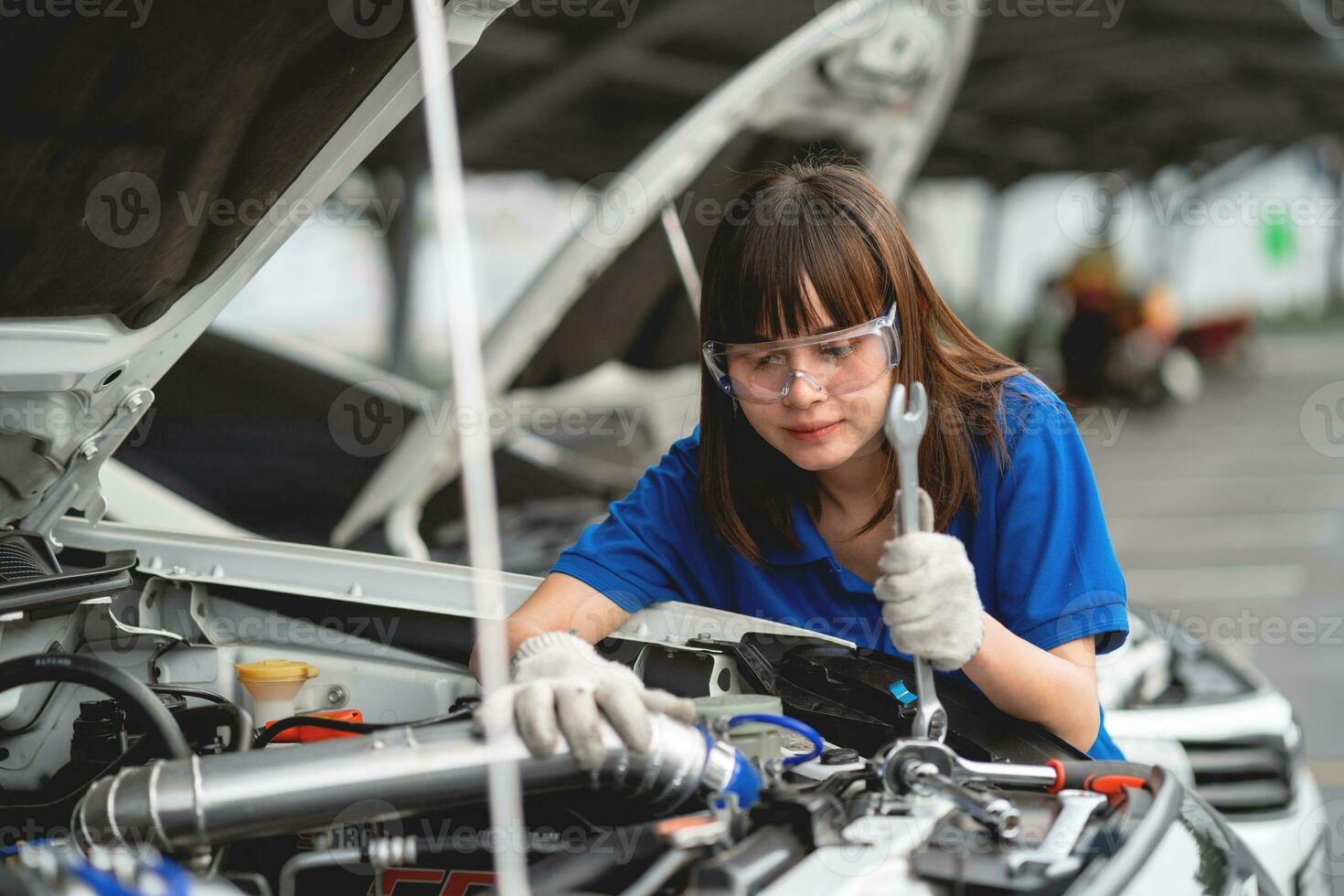 profissional serviço conceito. profissional ásia fêmea mecânico verificação e reparação carro gorro dentro garagem às garagem carro mecânico carro manutenção conceito foto