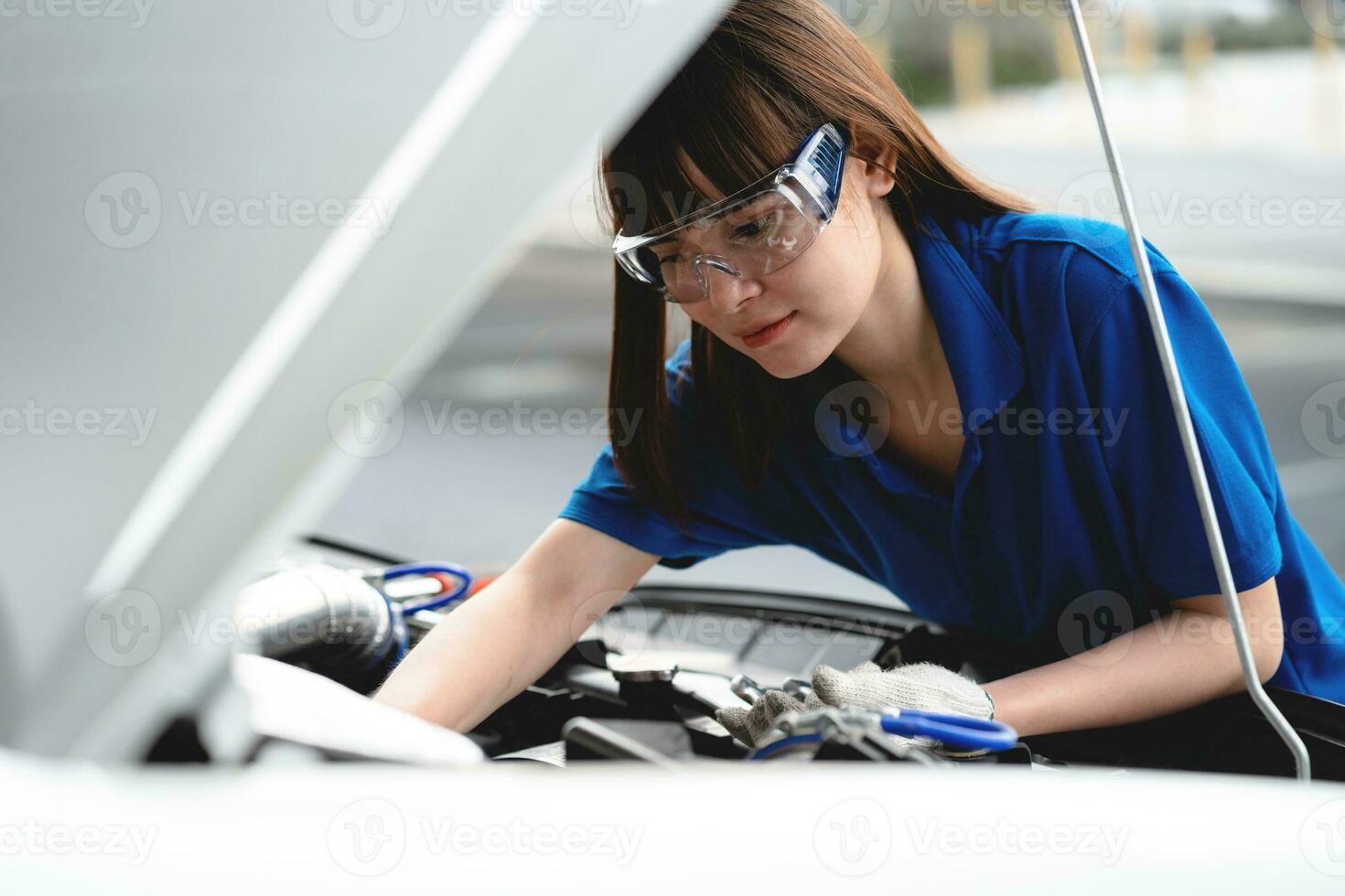 profissional serviço conceito. profissional ásia fêmea mecânico verificação e reparação carro gorro dentro garagem às garagem carro mecânico carro manutenção conceito foto