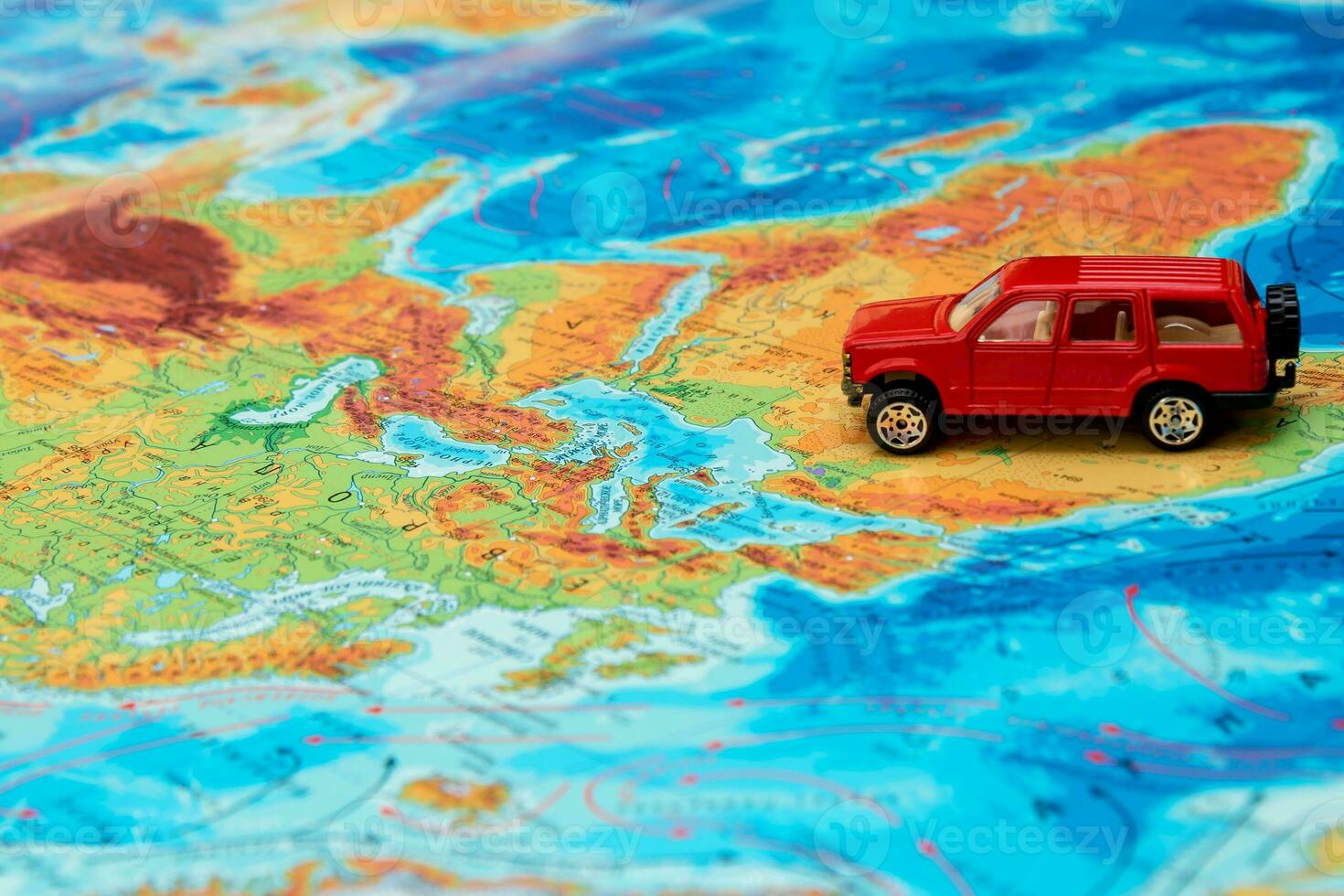 pequeno vermelho brinquedo carro em a fisica mapa do a mundo dentro África, viagem conteúdo foto