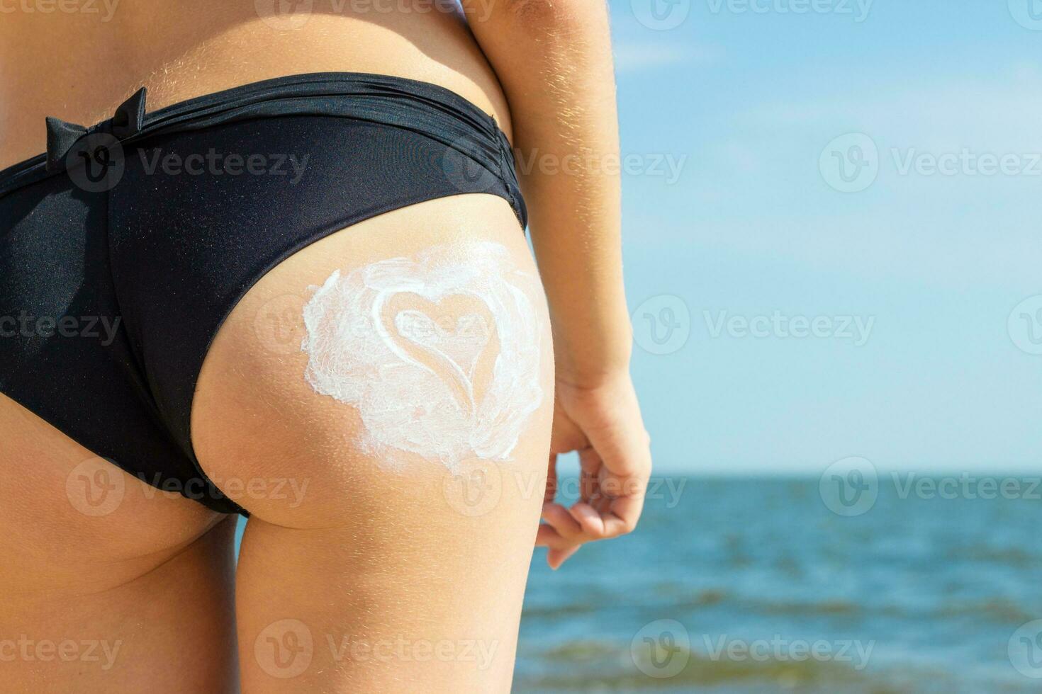 jovem lindo mulher com creme dentro a Formato do coração em dela bunda sobre mar fundo foto