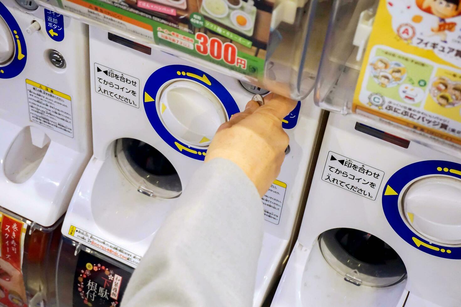 osaka, Japão, 2018 -mão do turista segurando moeda moedas compra uma gashapong vending máquina dentro Japão brinquedos fazer compras. gashapong é vending máquina dispensada cápsula brinquedos popular dentro Japão. foto