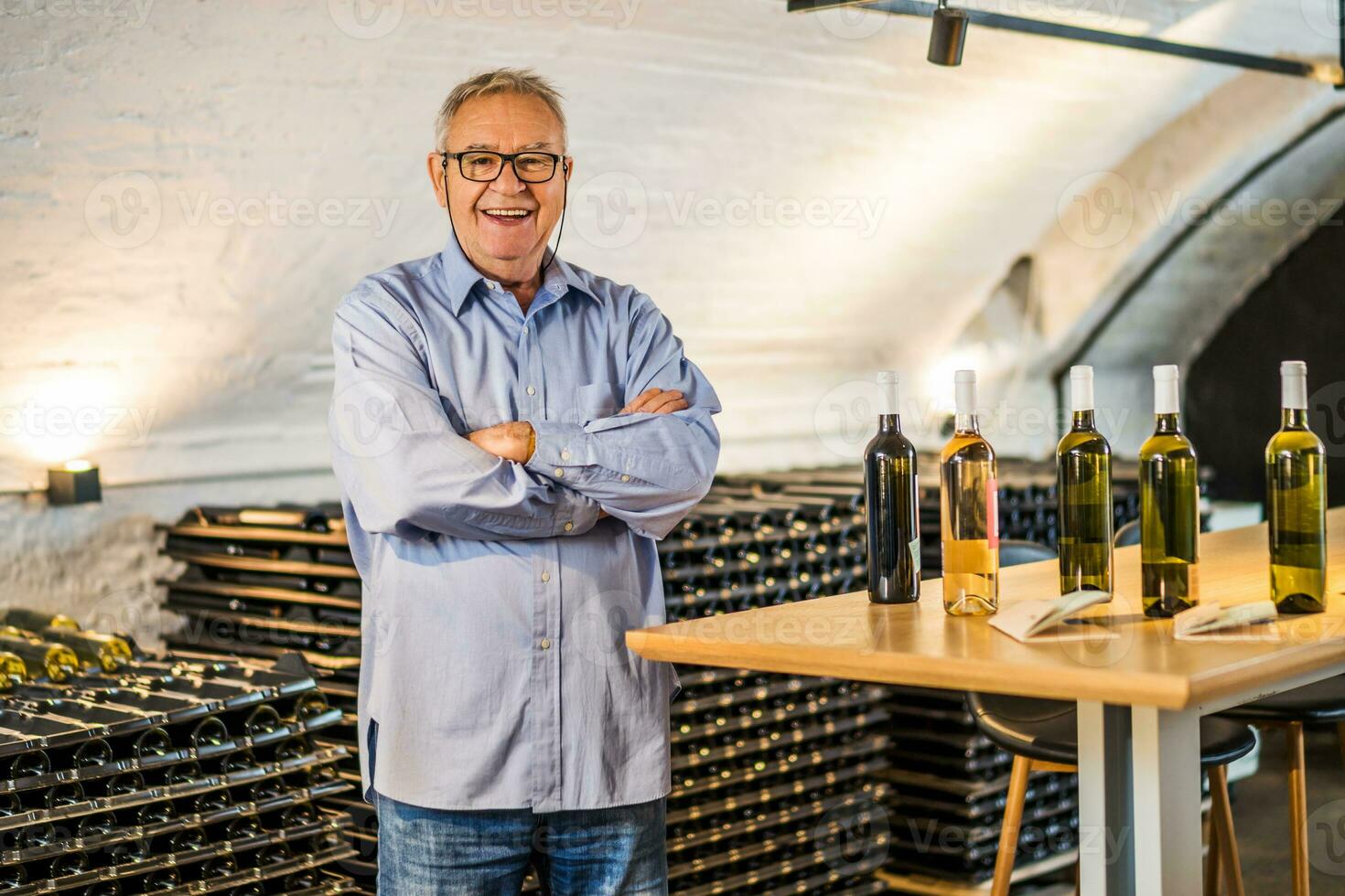 retrato do Senior homem quem possui adega. ele é examinando qualidade dentro dele vinho porão. indústria vinho fazer conceito. foto