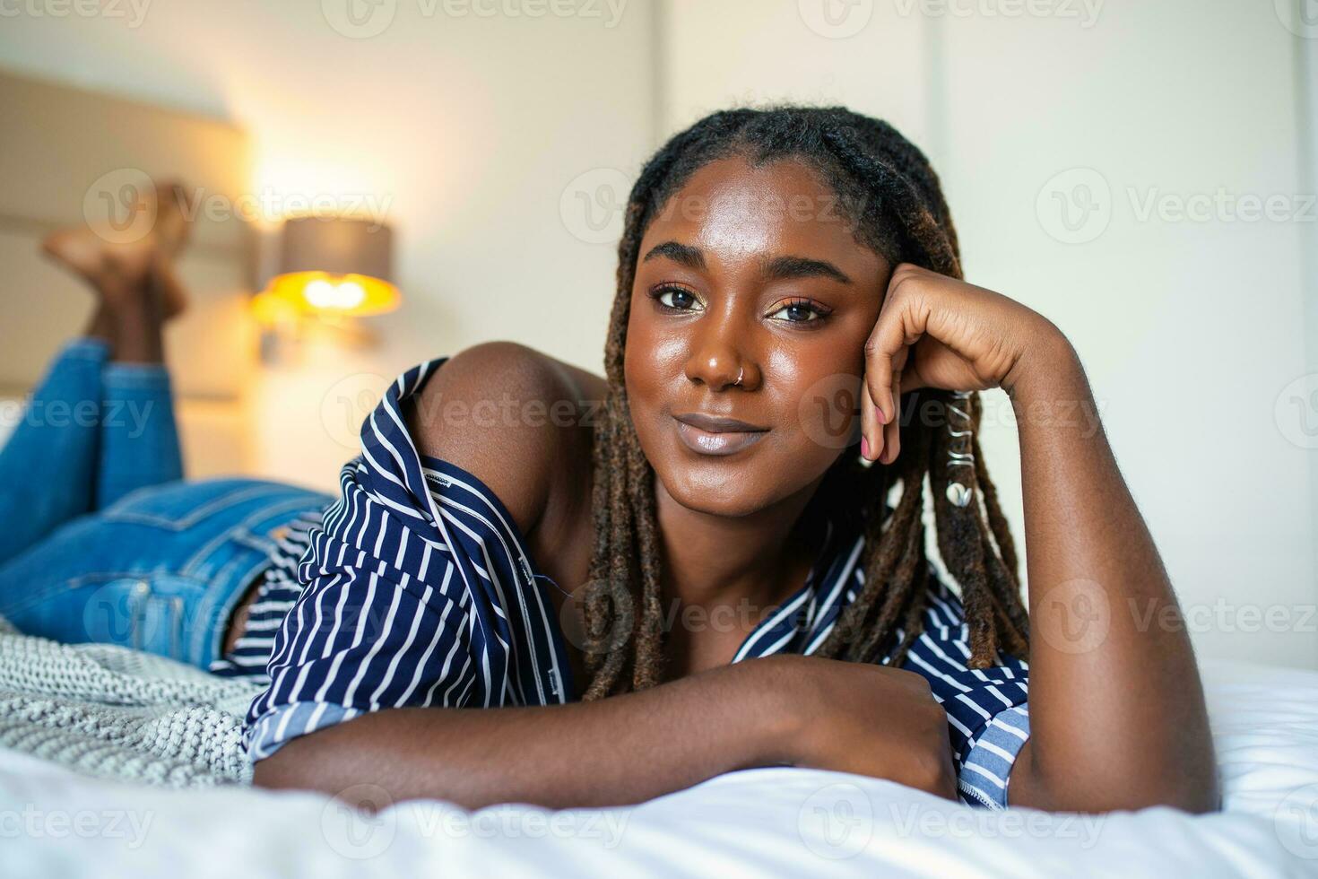 retrato do lindo e retrato sensual do lindo e sensual africano jovem mulher deitado em cama. lindo mulher deitado dentro cama africano jovem mulher deitado em cama. foto