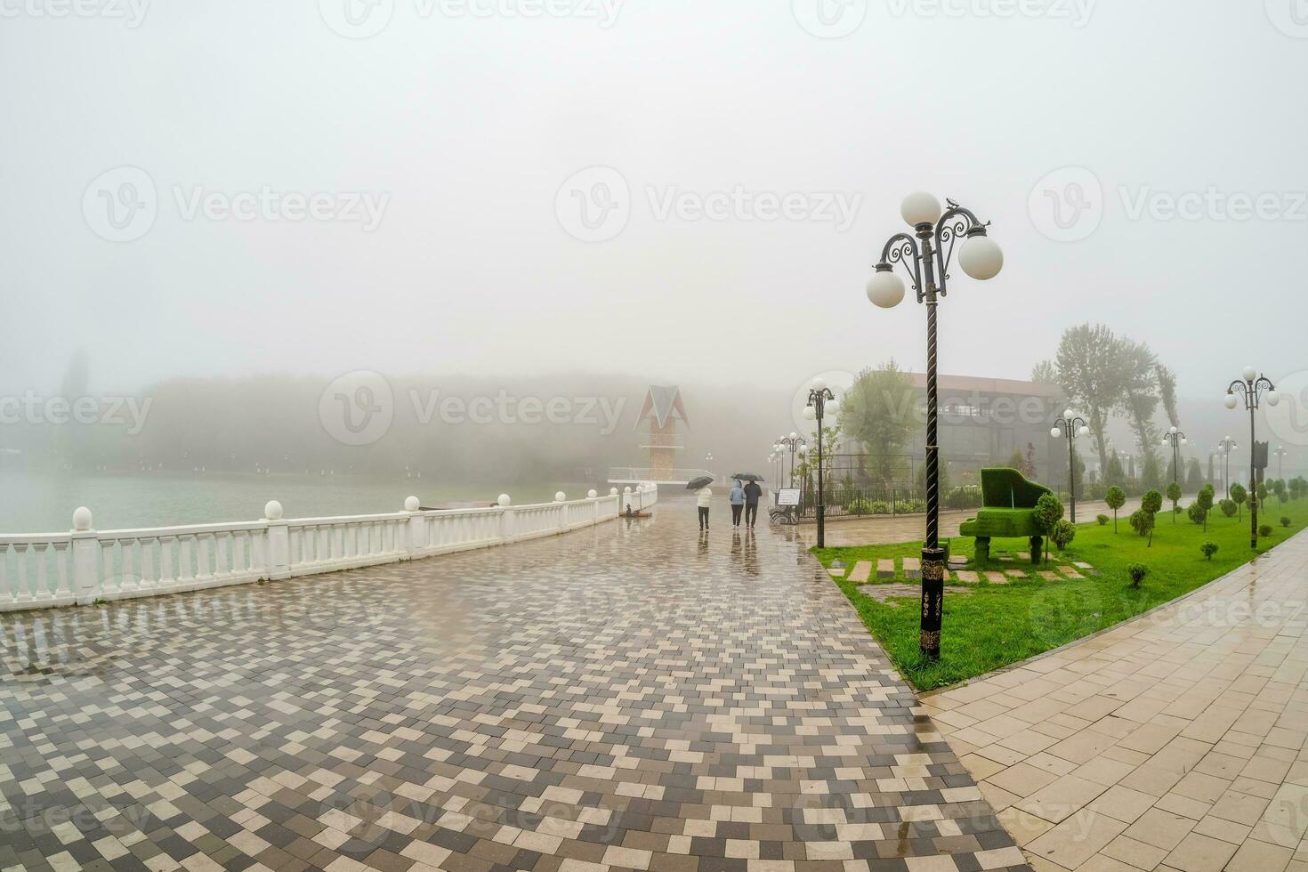 lindo molhado e nebuloso aterro com pessoas caminhando debaixo umb foto