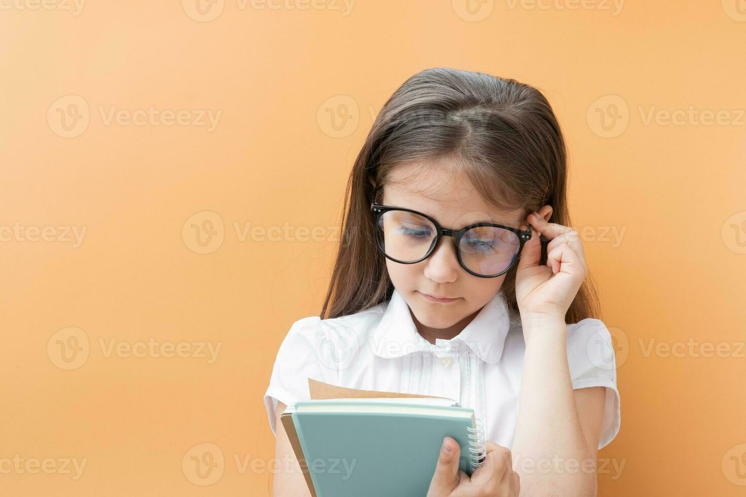 uma 7 anos de idade menina dentro óculos com cadernos. crianças Educação, Aprendendo conceito foto