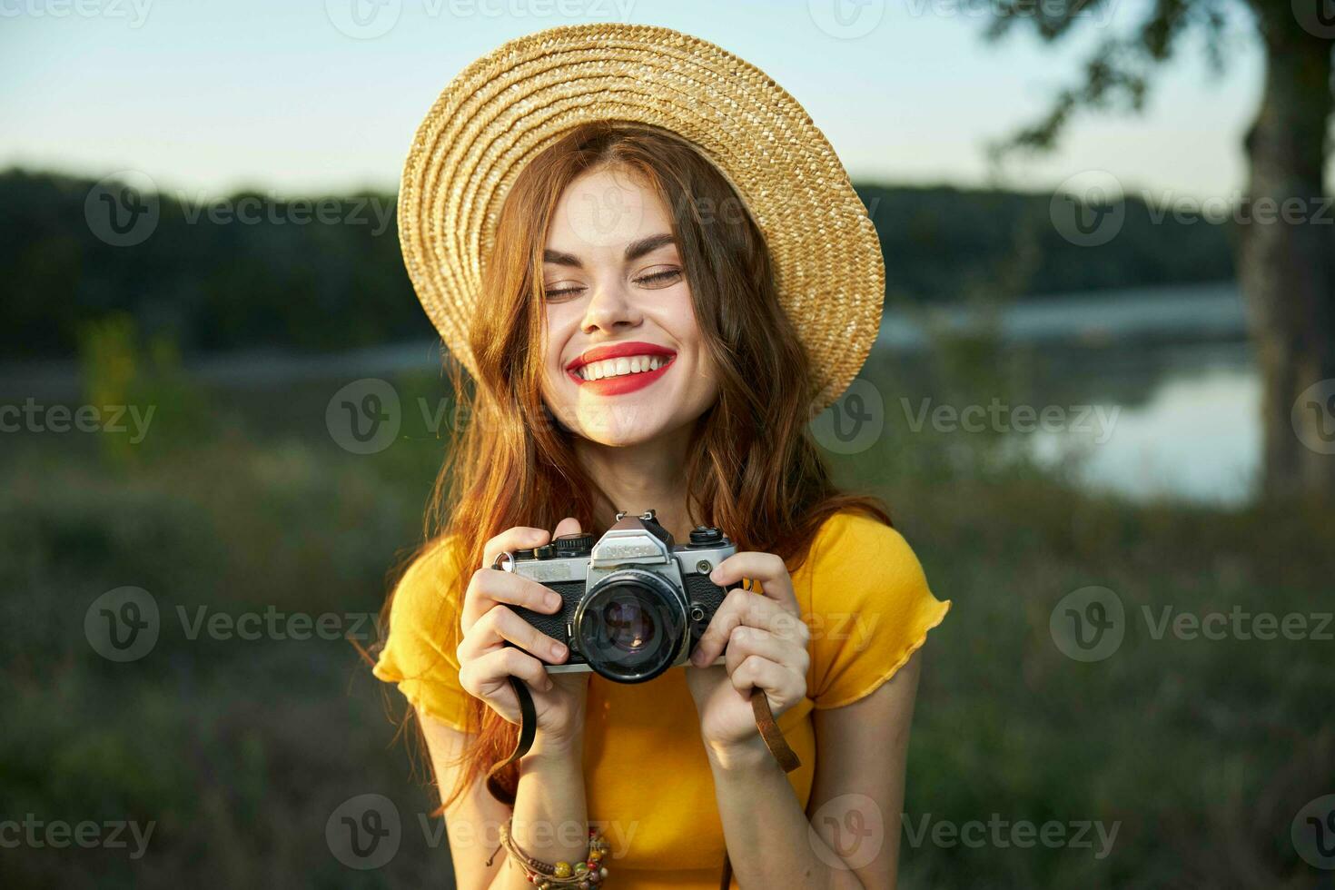 alegre mulher com fechadas olhos sorrir vermelho lábios Câmera lazer natureza foto