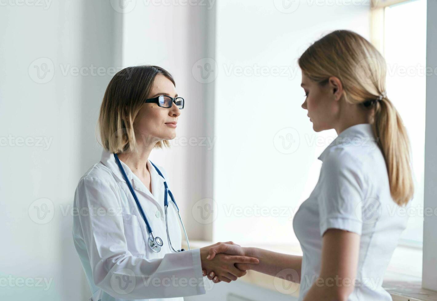 uma mulher médico dentro uma médico vestido escuta para a problemas do uma paciente dentro uma branco camiseta foto