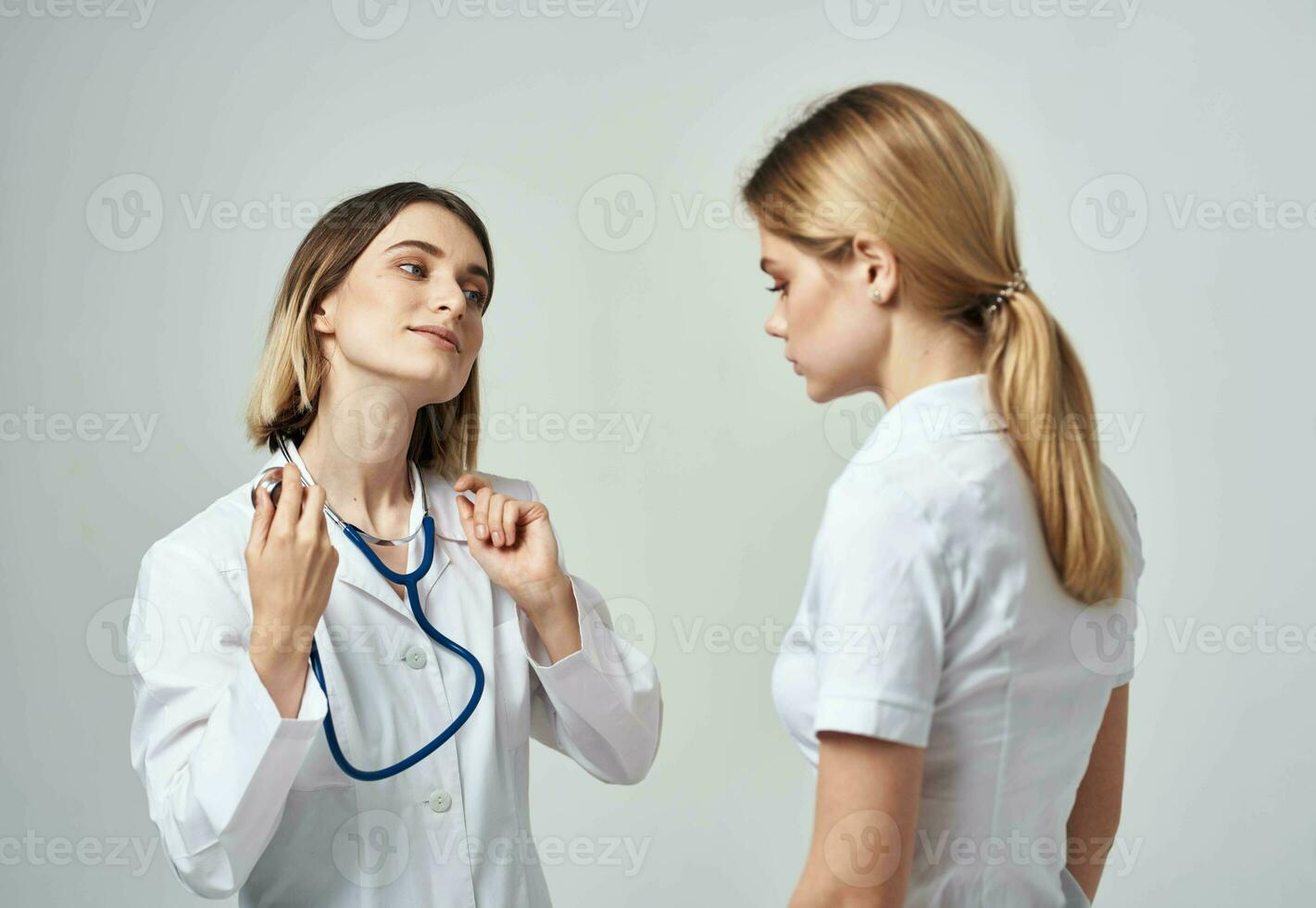 uma enfermeira com uma estetoscópio e uma paciente em uma luz fundo foto