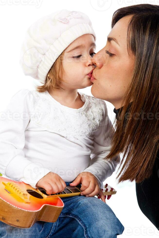 lindo pequeno Loiras menina e dela mãe jogando com uma brinquedo guitarra foto