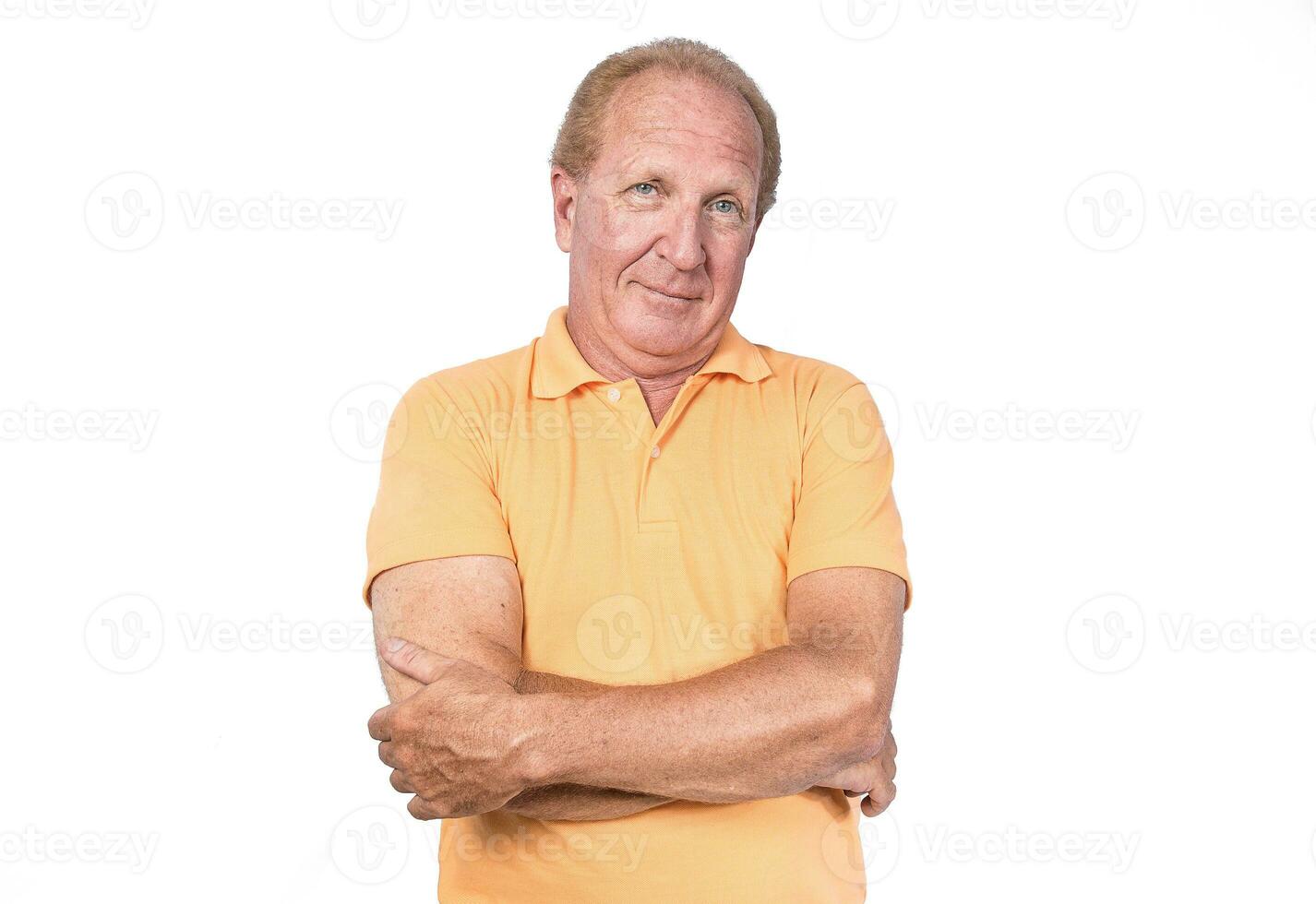 bonito velho homem dentro laranja camisa polo mãos cruzado foto