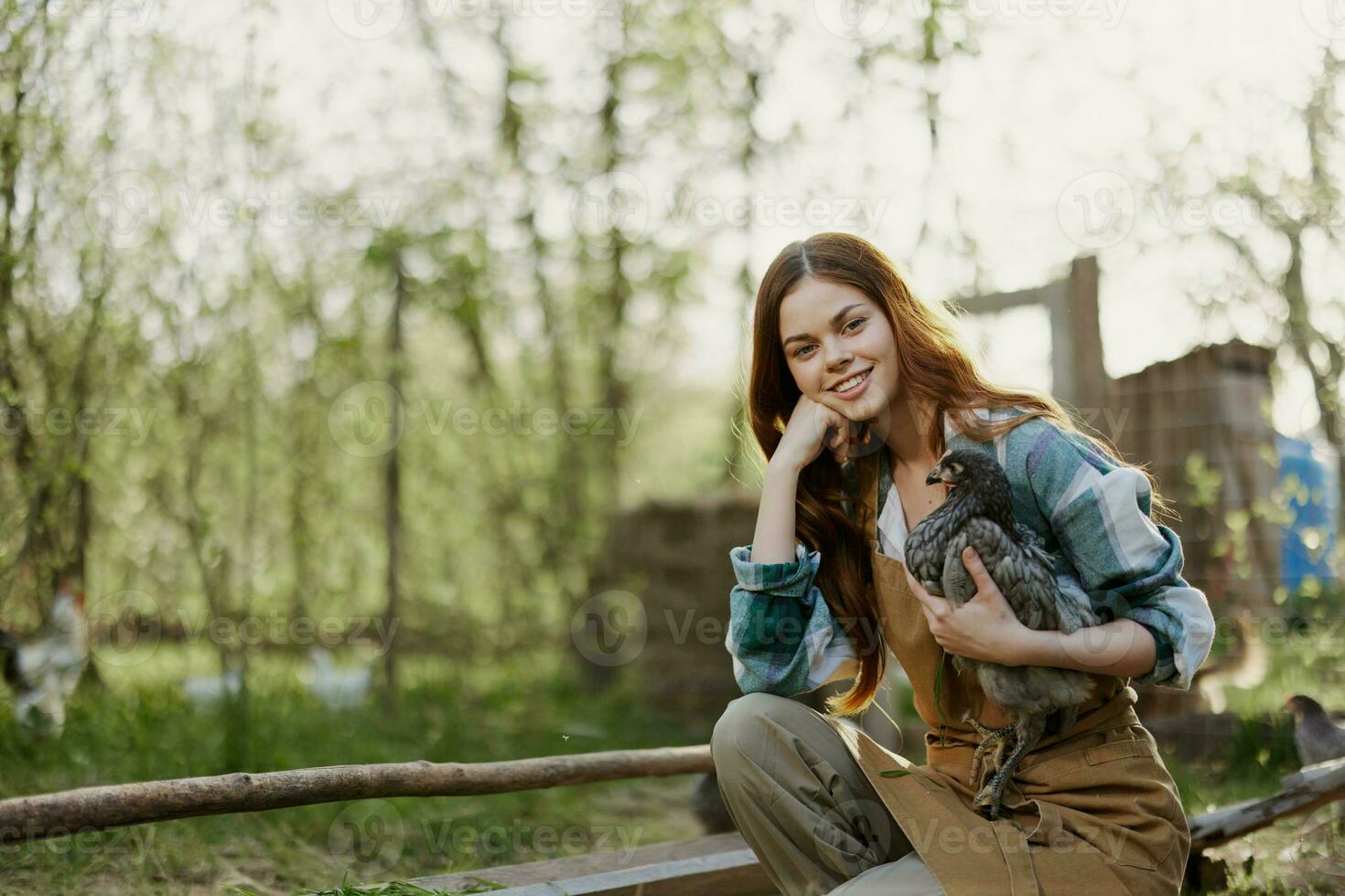 uma mulher examina uma frango dentro dela mãos e esfrega dela testa a partir de a fadiga do trabalhando em uma Fazenda e carinhoso para a pássaros ela feeds organicamente foto