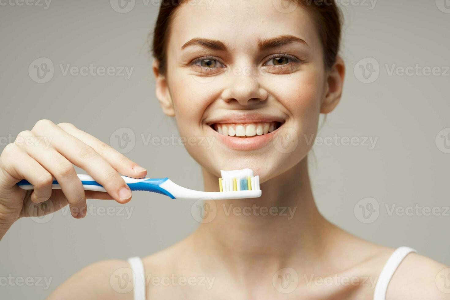 alegre mulher pasta de dentes escovar dentes dental saúde luz fundo foto