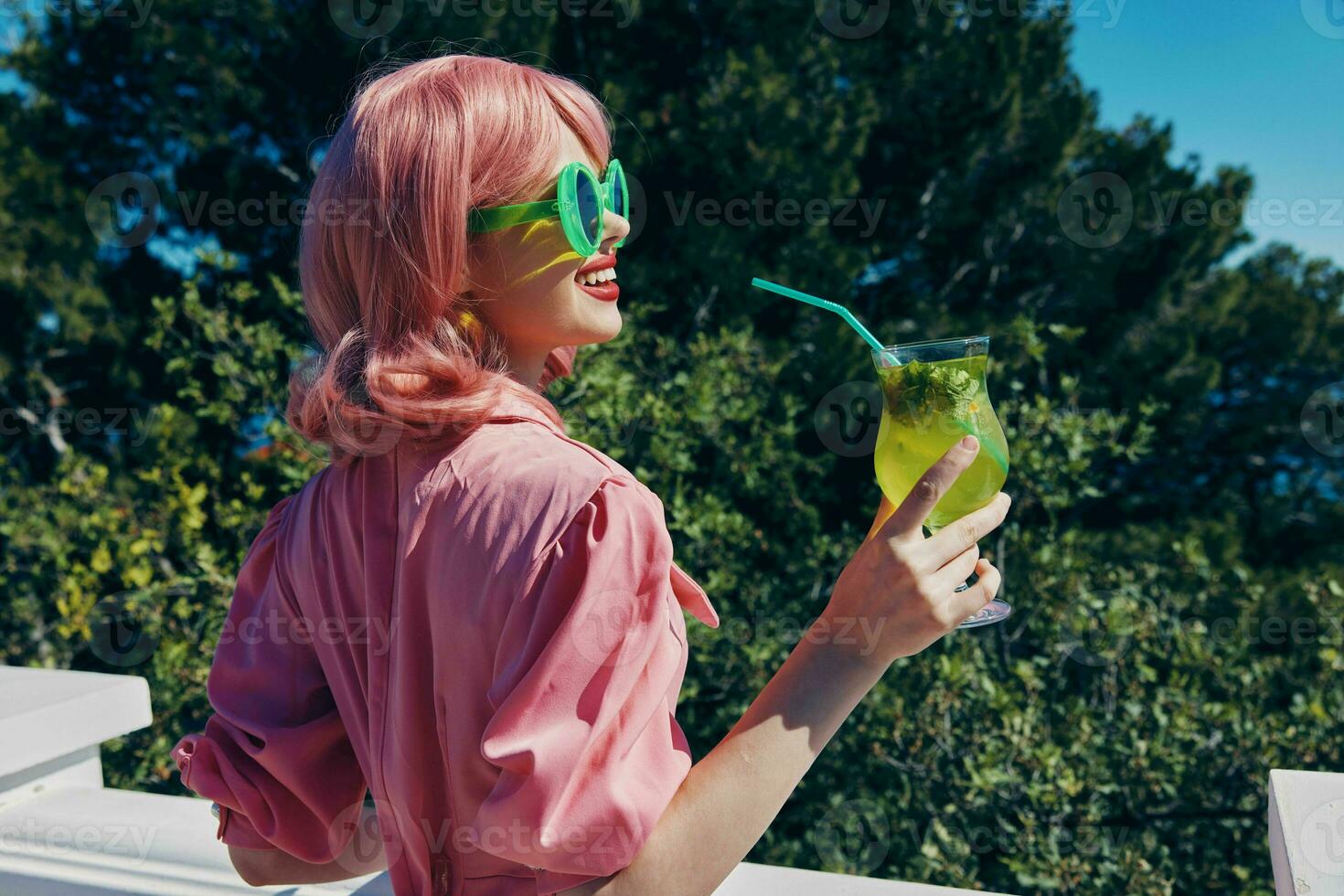 elegante mulher dentro verde oculos de sol com coquetel dentro verão ao ar livre verão dia foto