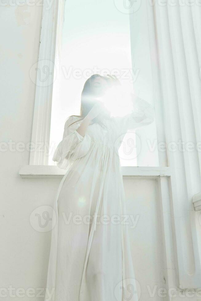 mulher dentro branco vestir raios Sol janela posando foto