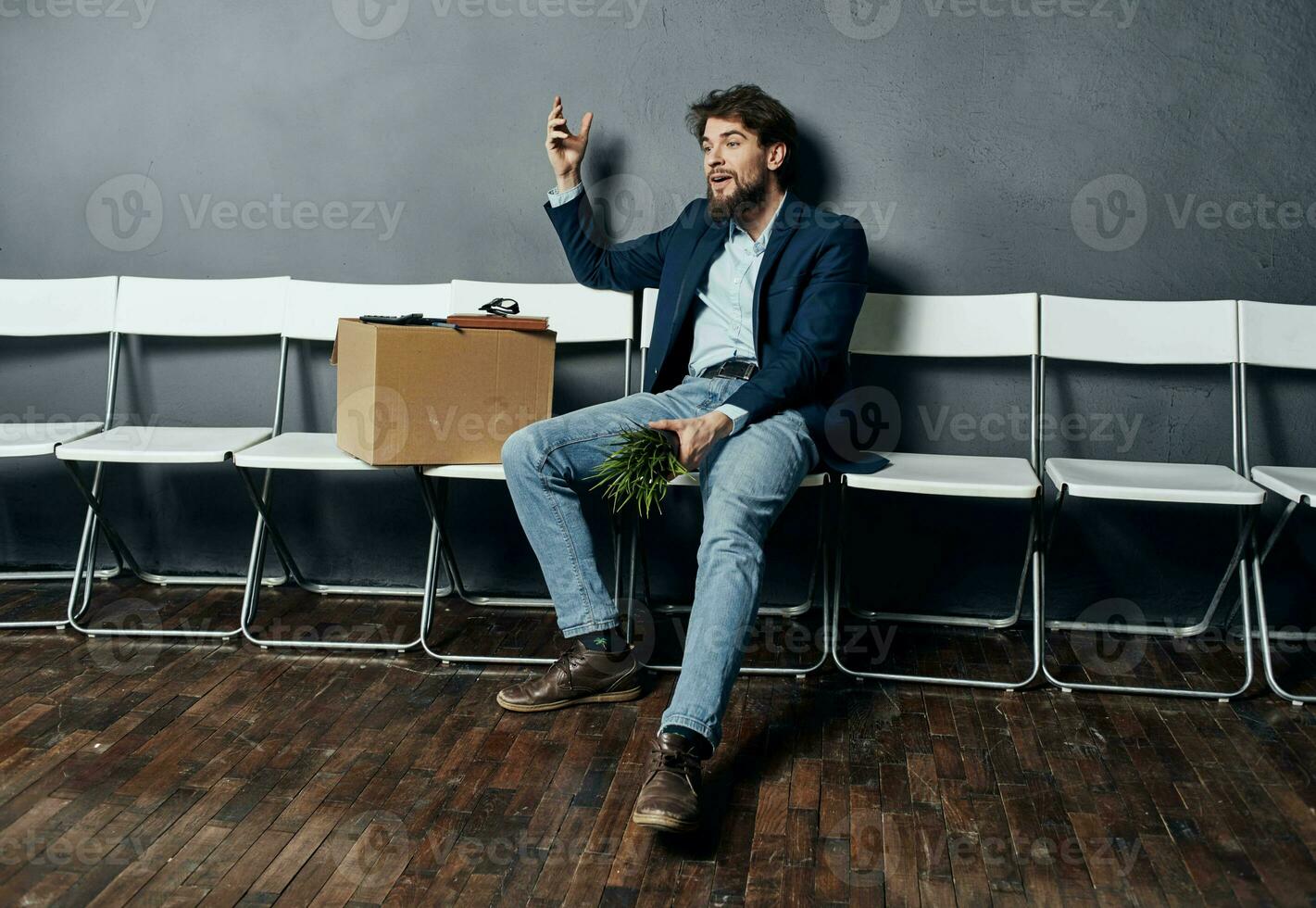 desapontado homem sentado em cadeiras com uma caixa trabalho procurar foto