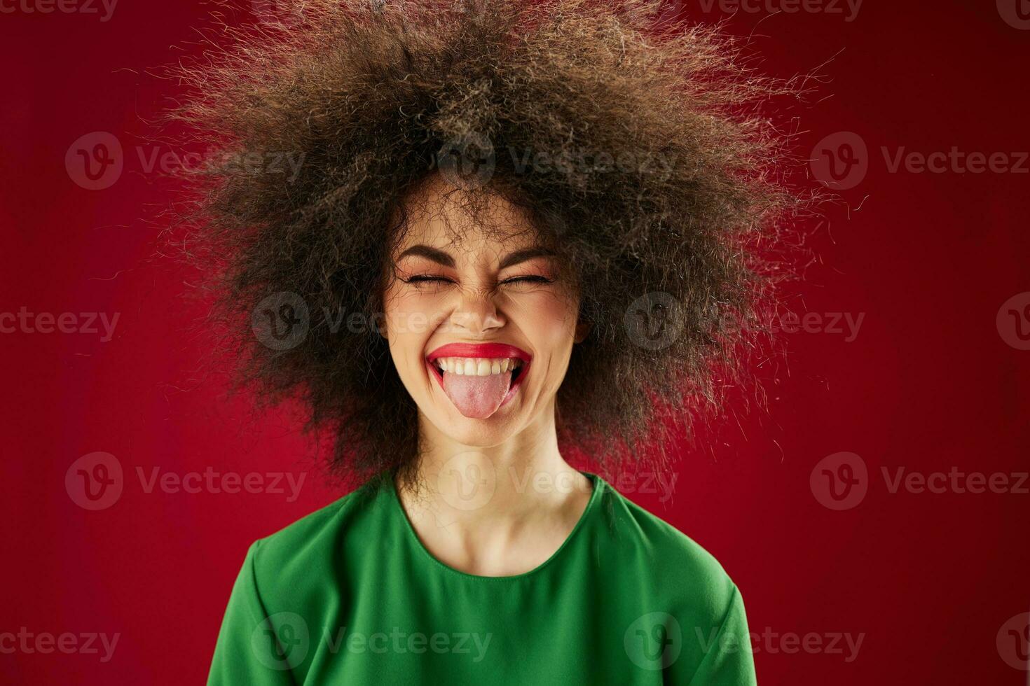 bonita jovem fêmea com encaracolado cabelo careta posando emoção vermelho fundo inalterado foto