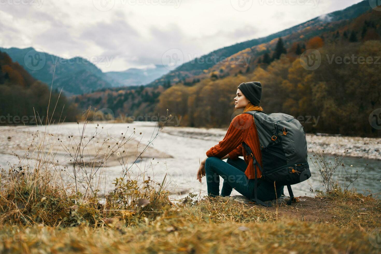 mulher viaja dentro a montanhas perto a rio dentro a Prado dentro a floresta descansar relaxar foto