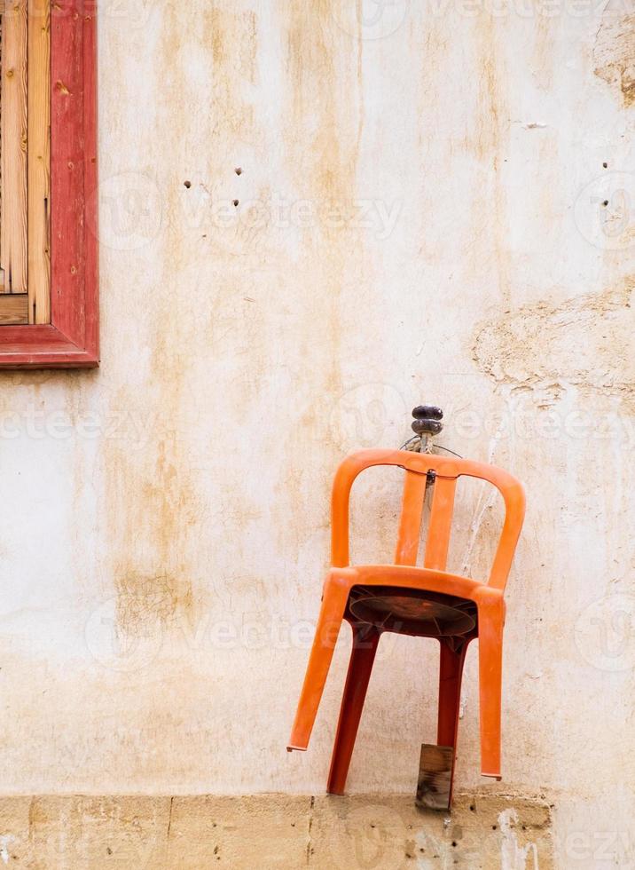 cadeira laranja pendurada na parede de uma casa tradicional na cidade velha de nicosia, chipre foto