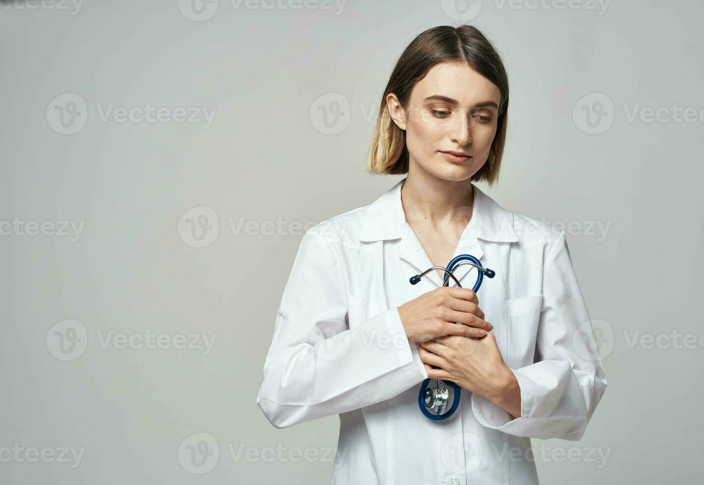 uma profissional médico dentro uma médico vestido detém uma estetoscópio dentro dele mão foto