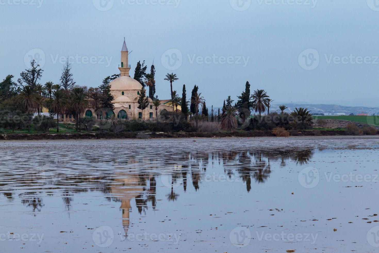 hala sultan tekke e reflexão sobre o lago salgado de larnaca, chipre foto