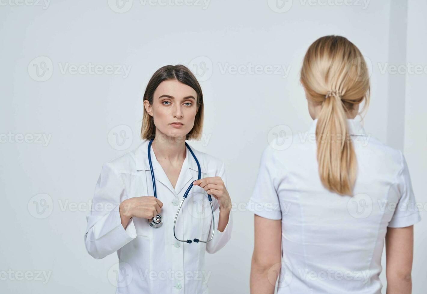 profissional médico enfermeira shakes mãos com uma paciente e uma estetoscópio por aí dela pescoço foto