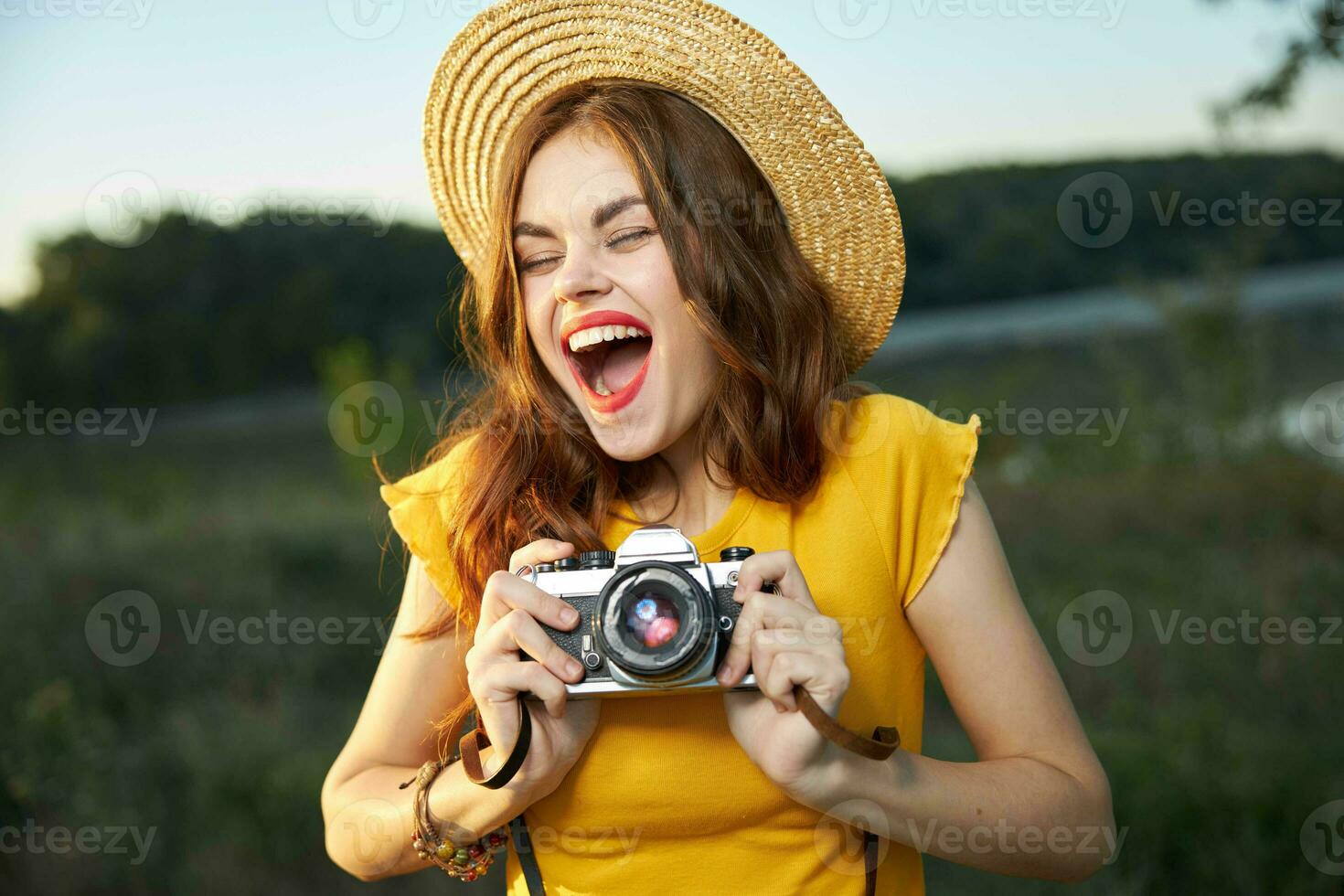 emocional mulher com aberto boca com uma Câmera dentro a mãos do lazer natureza foto