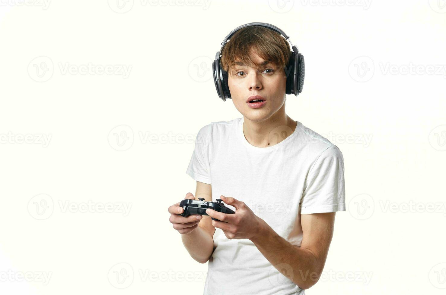 cara dentro uma branco camiseta dentro fones de ouvido com uma controle de video game vídeo jogos tecnologia jogador foto