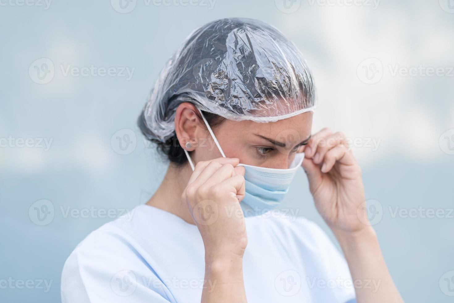 médica colocando sua máscara facial foto
