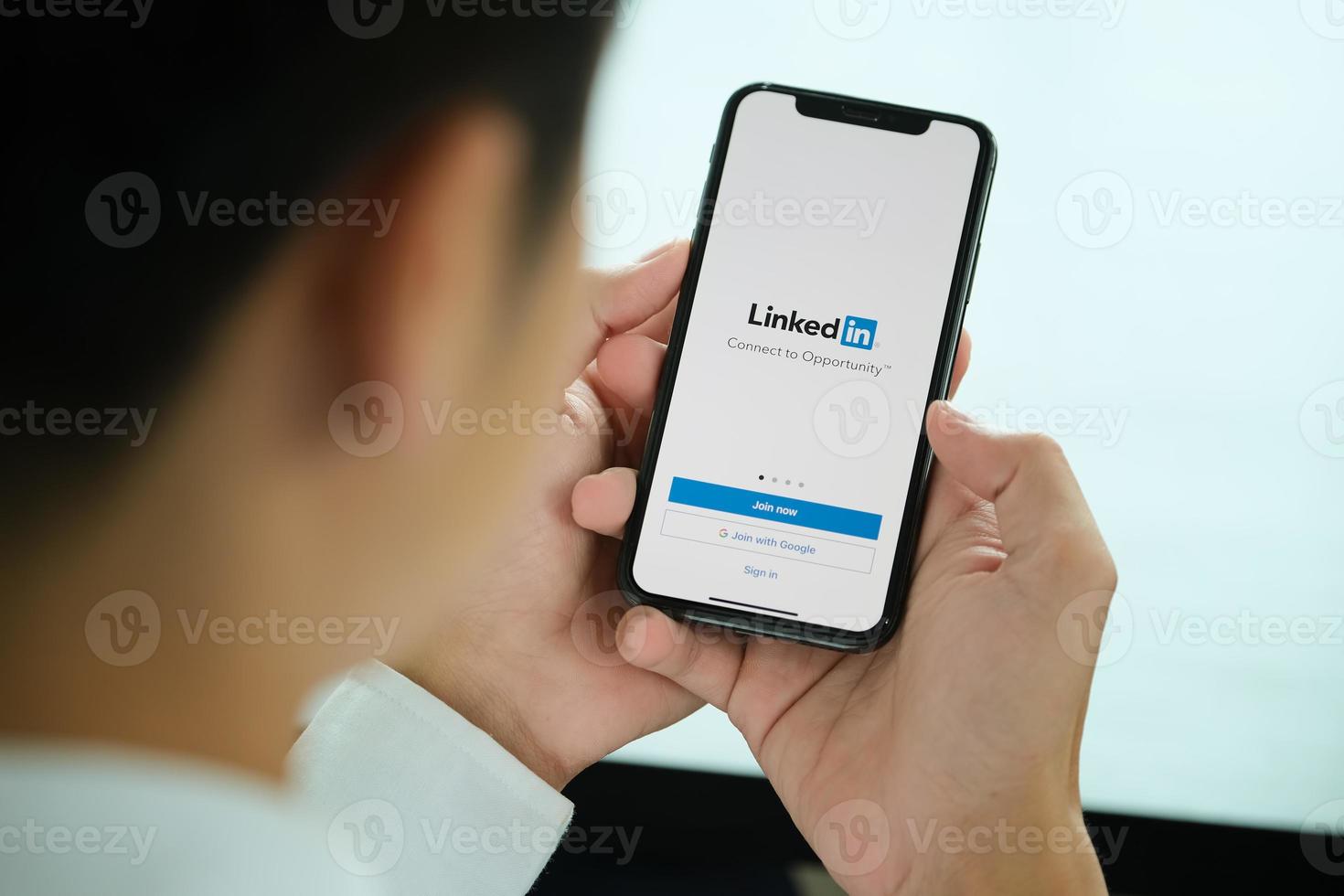 chiang mai, tailândia, 23 de janeiro de 2021 - homem apontando para um telefone com o LinkedIn nele foto