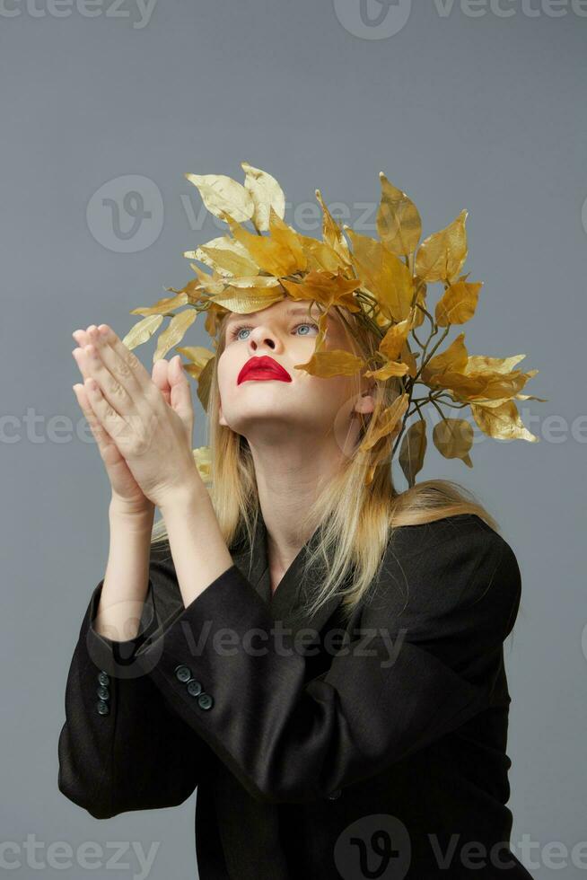 elegante mulher dourado folhas guirlanda Preto blazer vermelho lábios estúdio modelo inalterado foto