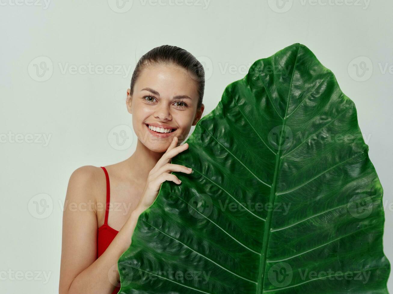 sorridente mulher dentro vermelho roupa de banho Palma folha exótico luz fundo foto