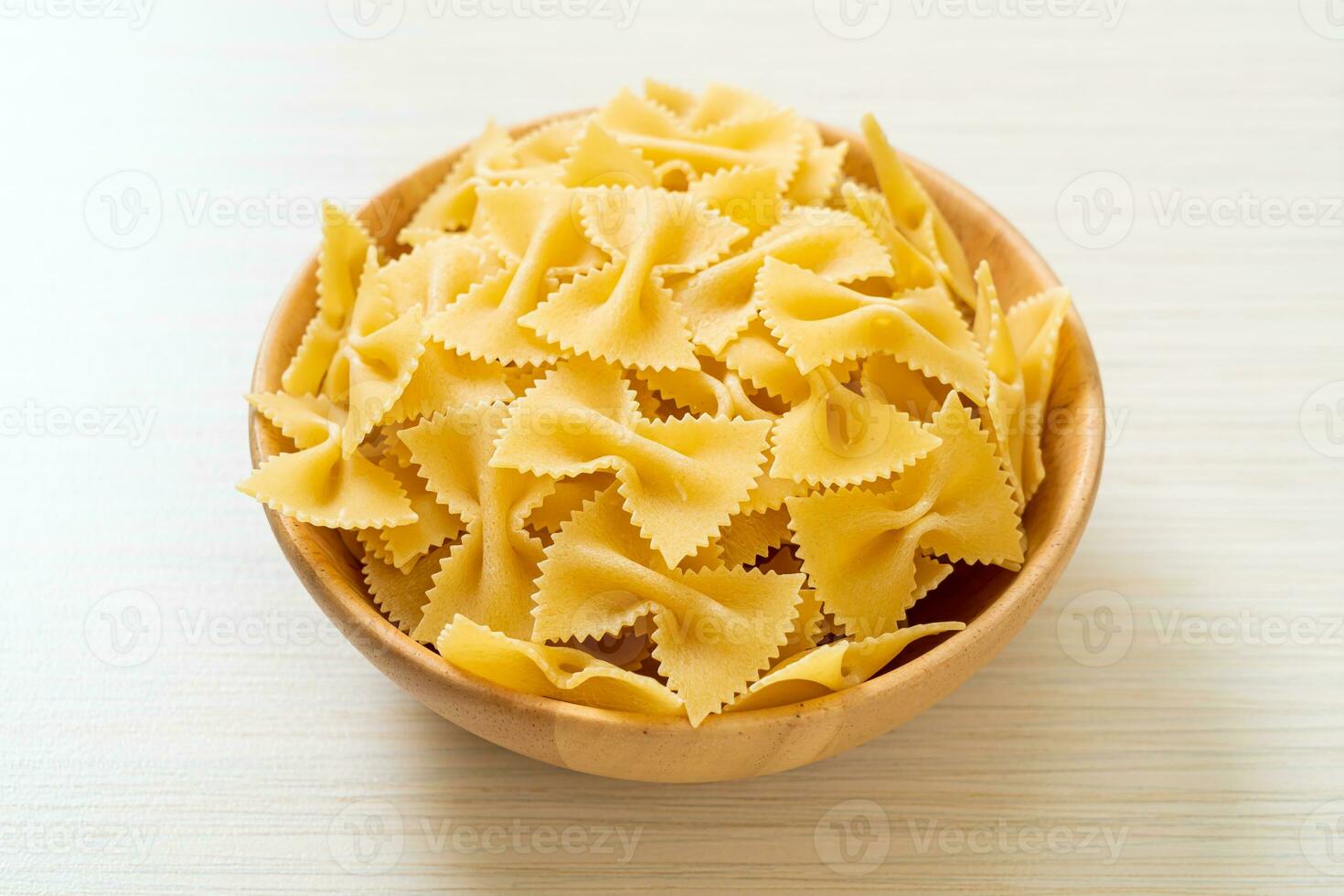 macarrão farfalle seco e cru na tigela foto