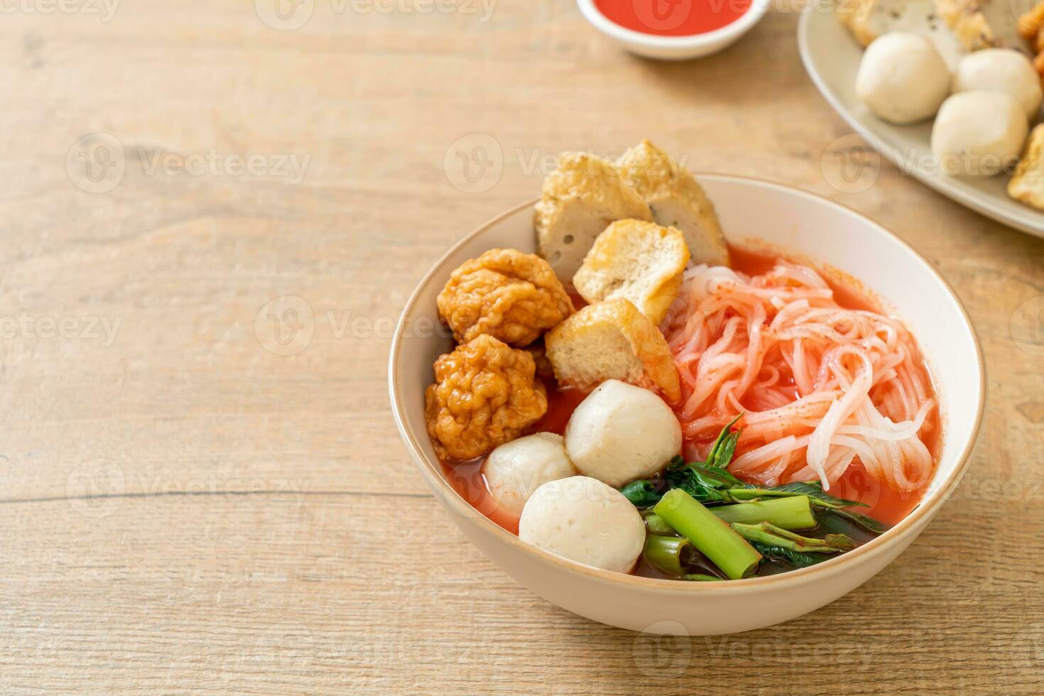 pequeno macarrão de arroz achatado com bolinhos de peixe e bolinhos de camarão na sopa rosa, yen ta quatro ou yen ta fo foto