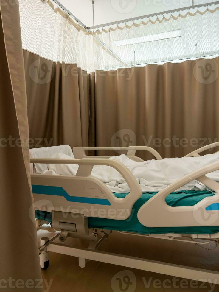 a ajustável hospital cama com uma paciente deitado dentro a branco cobertor. foto