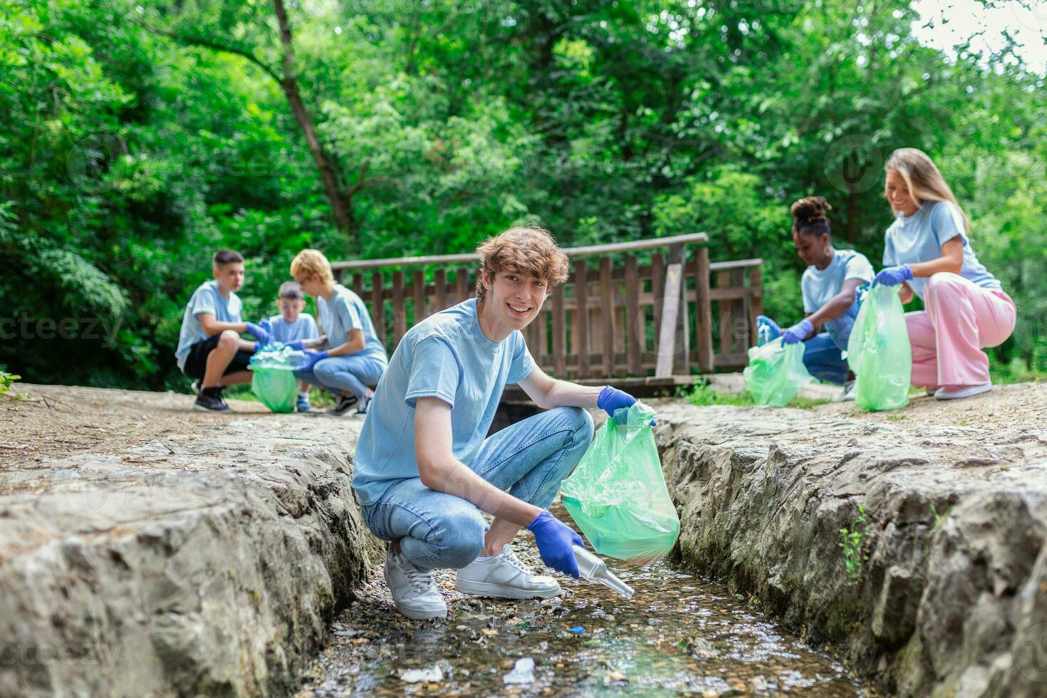 colecionar lixo a partir de a rio. homem colecionar plástico lixo em costa do a rio. limpeza meio Ambiente conceito foto