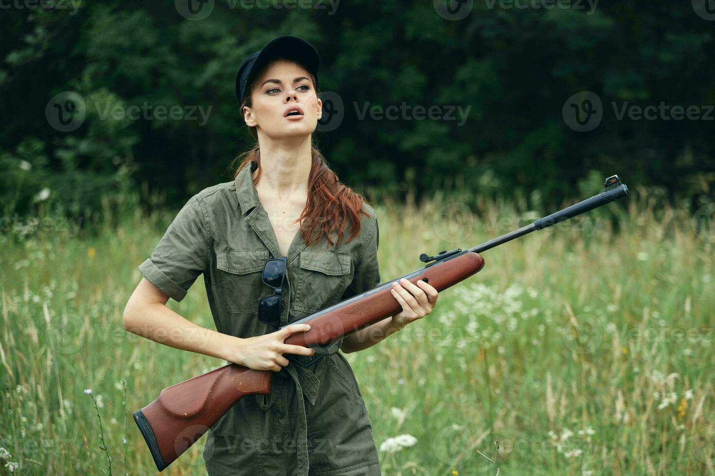 militares mulher com armas dentro mão, uma verde macacão parece para a lado Preto boné foto