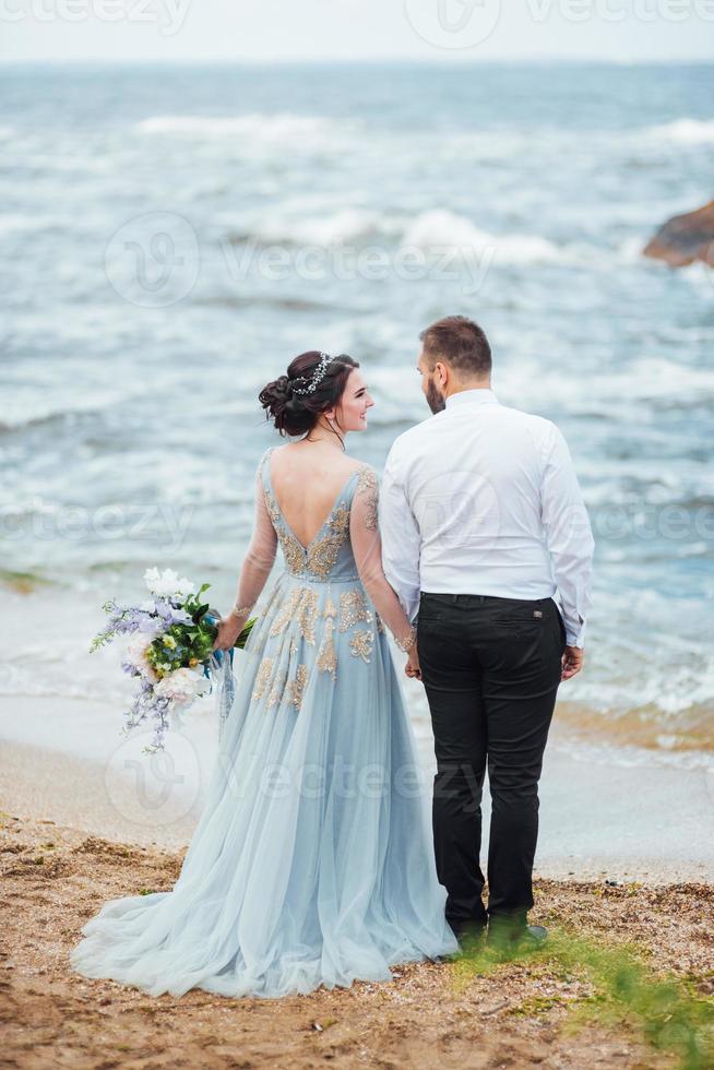 o mesmo casal com uma noiva em um vestido azul anda foto