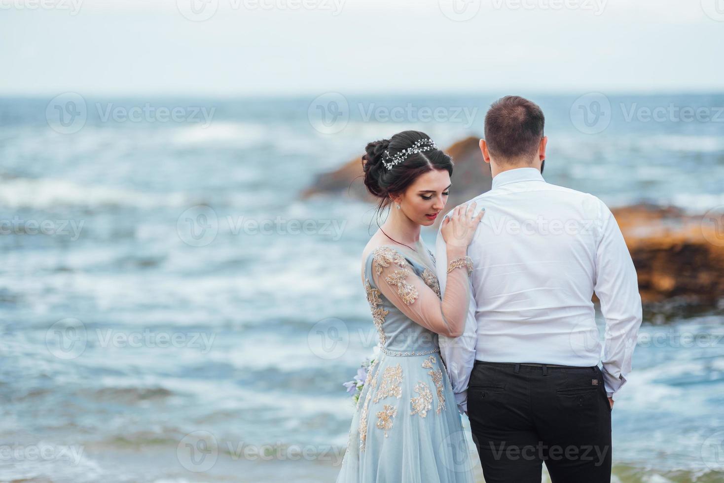 o mesmo casal com uma noiva em um vestido azul anda foto