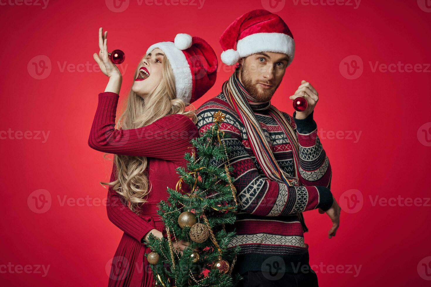 alegre jovem casal Natal árvore brinquedos feriado vermelho fundo foto