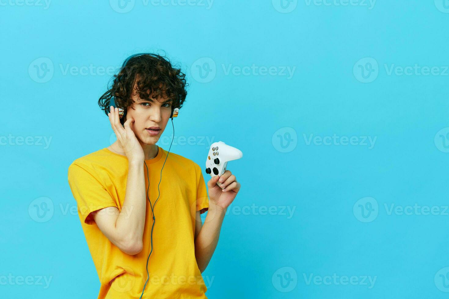 homem dentro fones de ouvido tocam jogos controle azul fundo foto