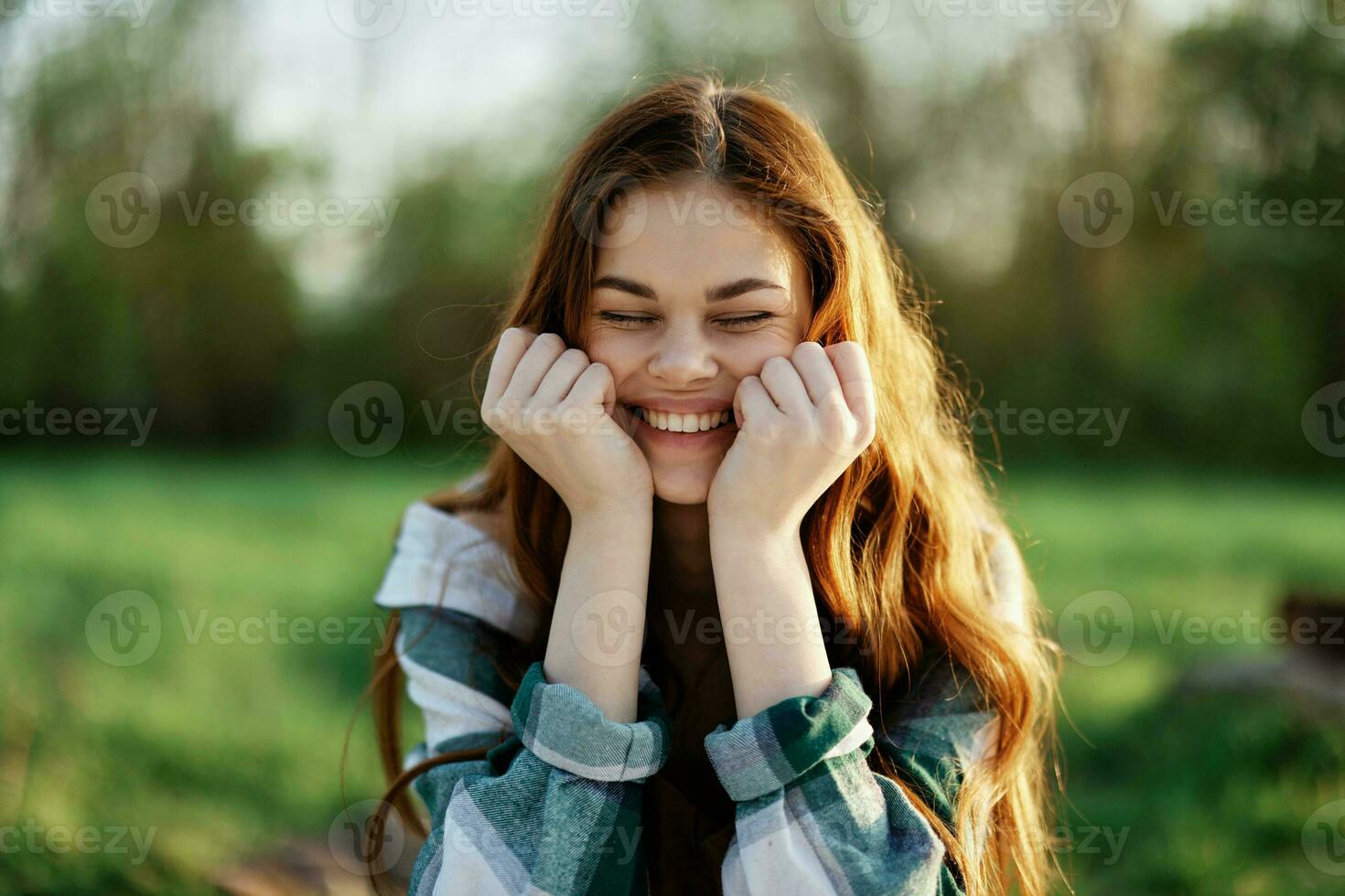 uma lindo mulher ao ar livre dentro uma verde parque risos e sorrisos Como ela parece para dentro a Câmera às pôr do sol dentro a Sol. fechar-se retrato foto