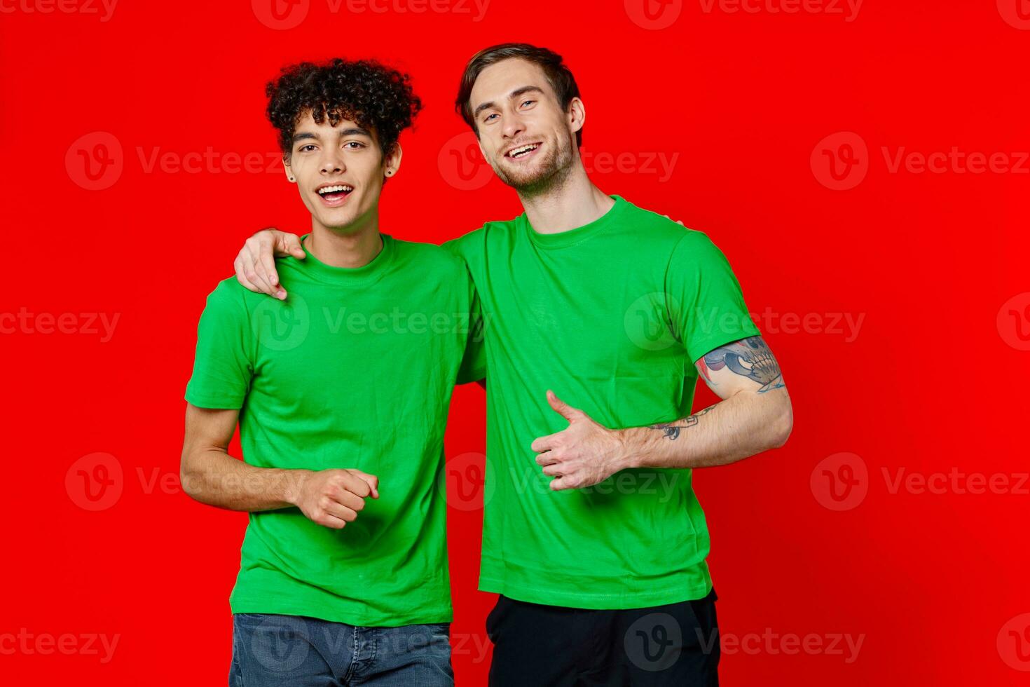 dois homem verde Camisetas abraço emoções amizade vermelho fundo foto