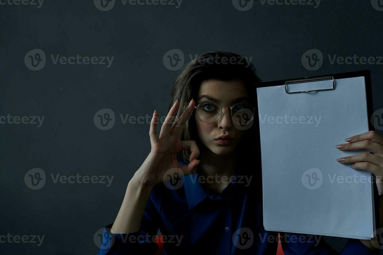 o negócio mulher com óculos senta às a mesa enquanto segurando cópia de espaço foto