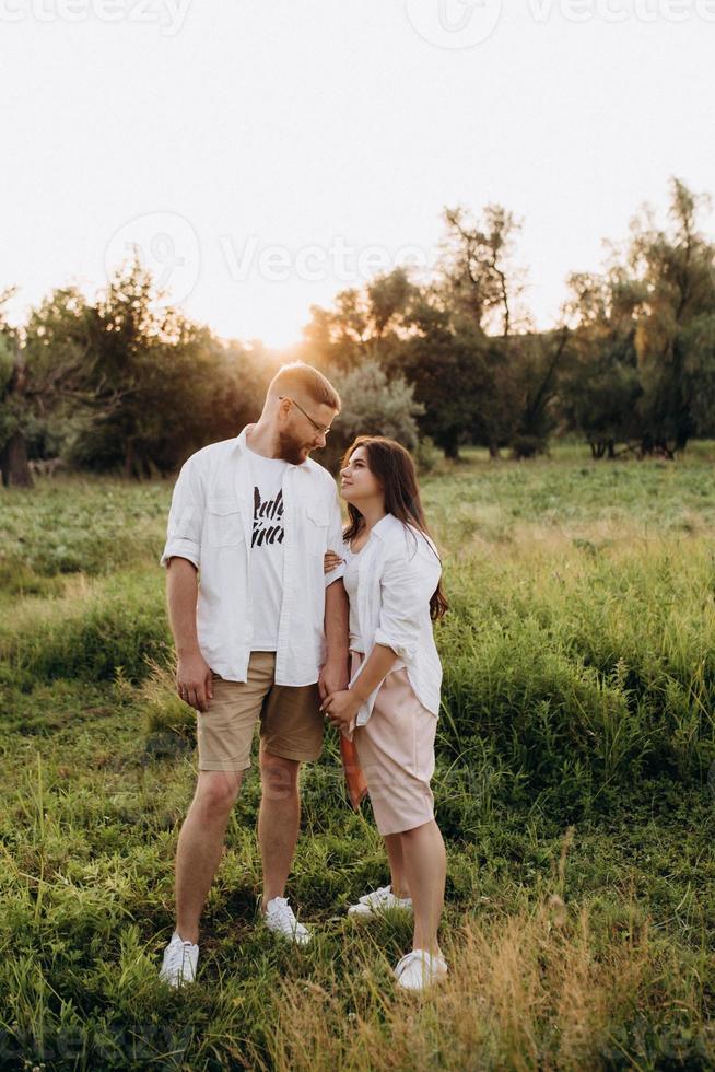 jovem casal apaixonado um cara com barba e uma garota com cabelos escuros em roupas leves foto