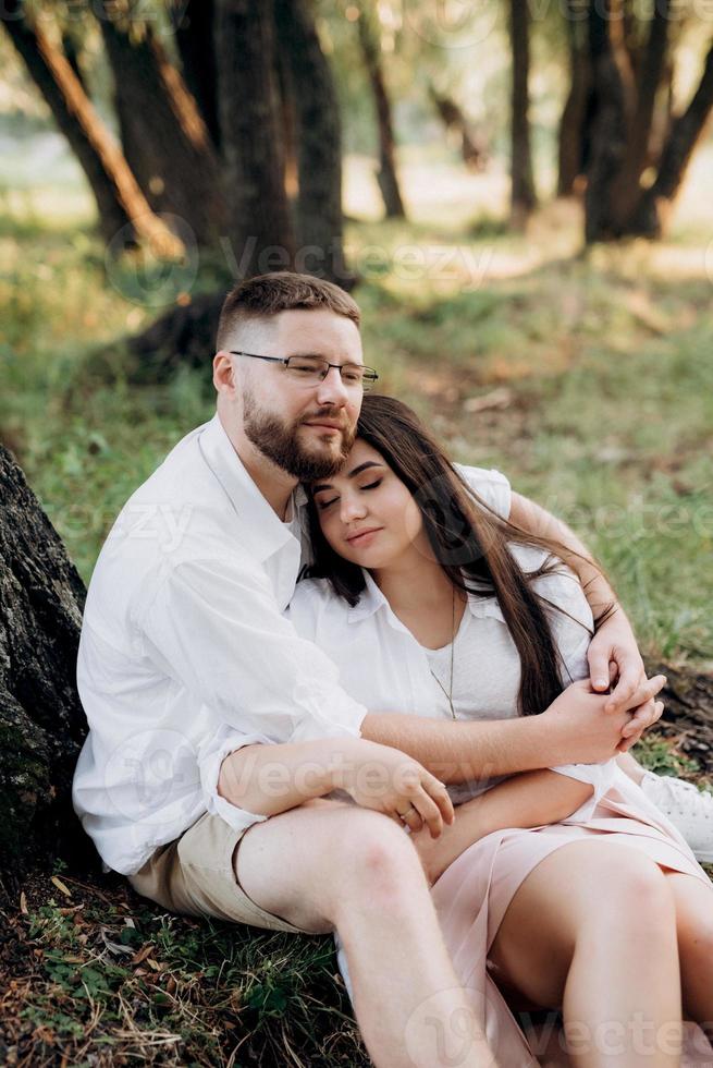 jovem casal apaixonado um cara com barba e uma garota com cabelos escuros em roupas leves foto