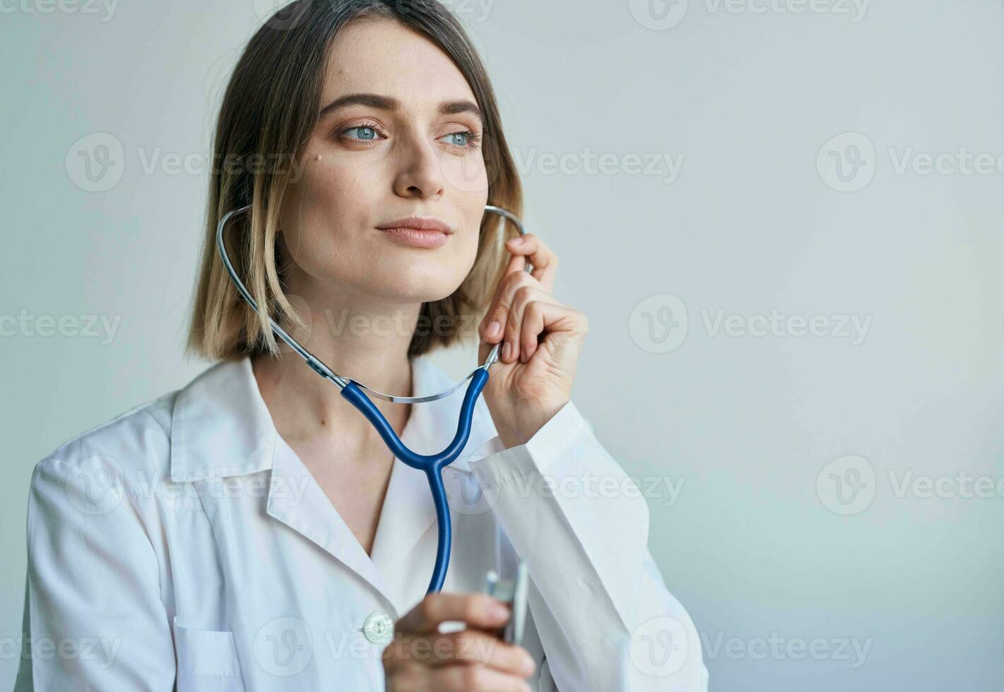 mulher com profissional estetoscópio médico dentro médico vestido dentro brilhante quarto foto