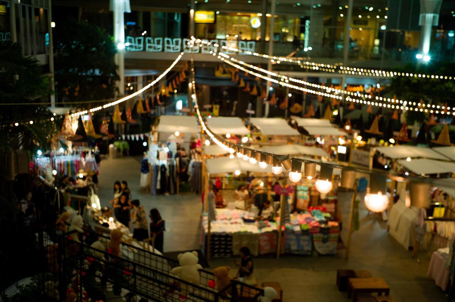 paisagem urbana e paisagem do mercado noturno de pulgas em um shopping comunitário com as luzes seletivas do bokeh ao fundo foto