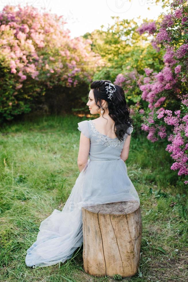 retrato de uma menina morena em um jardim lilás primavera foto