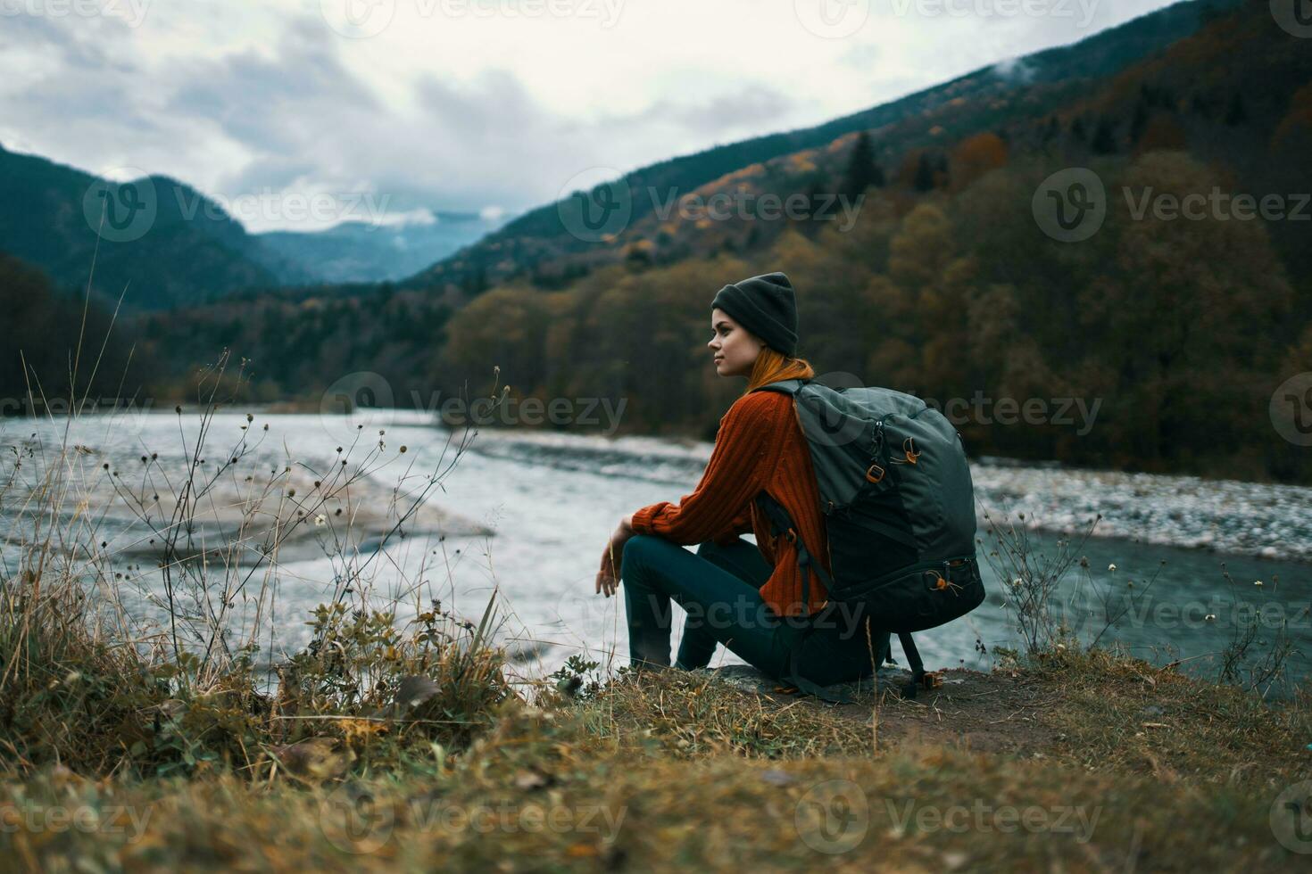 mulher viaja dentro a montanhas perto a rio dentro a Prado dentro a floresta descansar relaxar foto